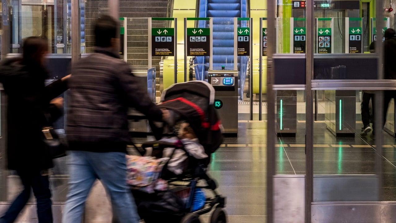 En familj med barnvagn går in på stationen